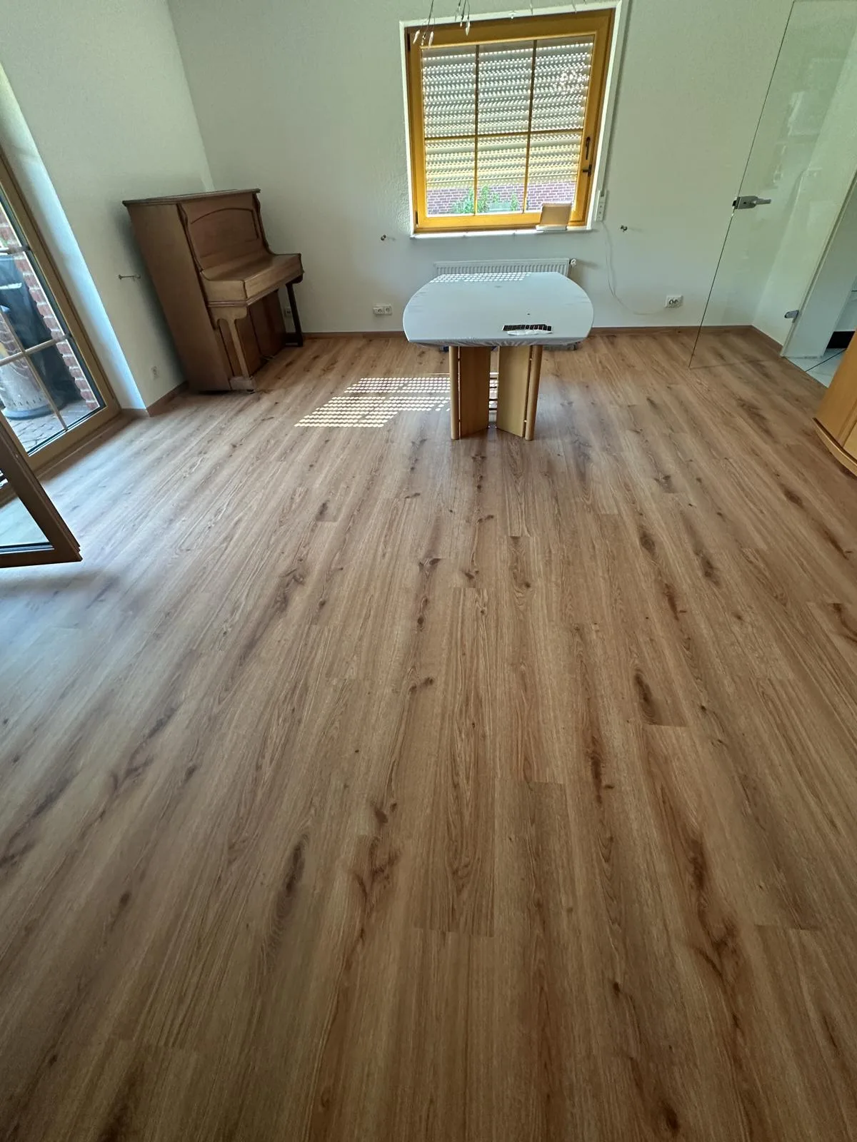 Neu verlegter Designboden in Holzoptik im Wohn- und Essbereich